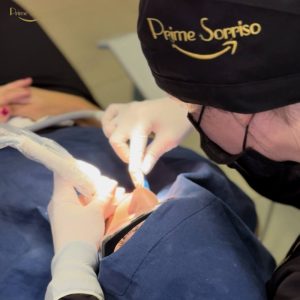dentista realizando limpeza dental profissional em paciente sorridente na Prime Sorriso
