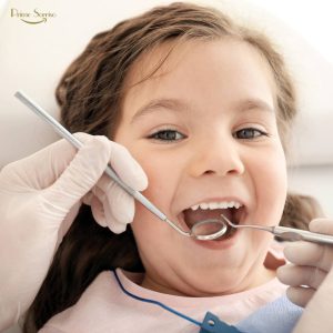 Criança na primeira consulta ao dentista com acompanhamento dos pais