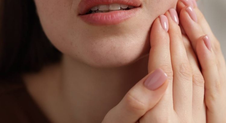 Pessoa com desconforto ao mastigar, representando necessidade de avaliação odontológica